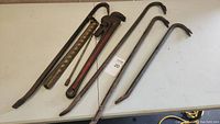 Photo of crow bars and pipe wrench laid out on table