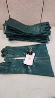 Stack of dark green heavy duty chemical resistant gloves with cotton flock lining, 17 inches long
