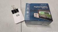 Sealed box of Magellan RoadMate 5202-LM GPS navigator with label 66 beside it.