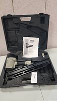 Porter Cable round head framing nailer in hard plastic case with instruction manual and hex keys.