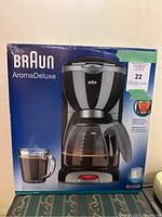 Photo of the Braun AromaDeluxe coffee maker box showing the product image, logo, and key features.