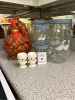 Photo showing the rooster cookie jar, two penguin egg cups, and three of the five glass storage jars with blue lids and white duck décor