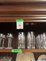 Shelf with four short crystal glasses, two tall cylindrical glasses, and four short faceted glasses.