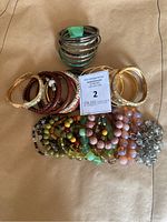 Overview of all bangles and beaded bracelets spread on a surface showing variety of styles and colors