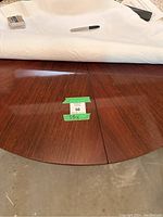 Close-up of the wood grain and high shine finish on the tabletop showing natural wood pattern and reflection under light.