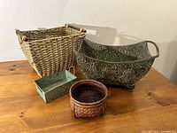 Four baskets including two metal and two wicker, shown on a wooden surface with clear lighting.