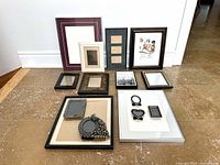 All 15 photo and document frames arranged on floor, showing size, styles and condition.