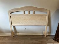 Full view of wooden headboard showing arched top and base supports
