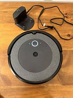 Top-down view of Roomba unit and charging station showing control panel and power cord