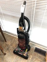 Front view of Bissell Powerforce bagless turbo vacuum showing upright design, dirt container, hose, power cord and control dial on base.