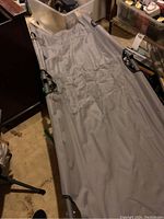 Woods camp cot fully expanded showing gray fabric and metal frame