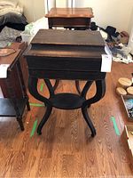 Front angle of the antique wooden vanity table showing its top and curved legs with shelf under.