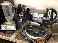 Photo of the assortment showing blender, knife set, toaster oven, kettle, French press, cupcake pan.