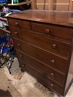 Front angle view showing full dresser with six drawers and round wooden knobs, highlighting overall design and finish.