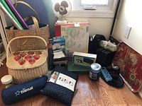 Wide view of lot showing sewing basket, wrapped paper, heaters, ironing boards, foot spa, cards and bags