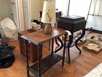 Full view of the wooden side table with the lamp on top, highlighting the table's surface and legs in a room setting.