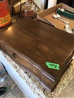 Closed wooden canteen with curved front and a green sticker labeled 'plate' on top.