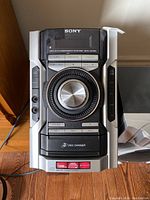 Top view of Sony HCD-E65 stereo system main unit showing central volume knob, disc changer, and control buttons
