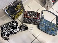 Photo showing four fabric handbags including one with matching small pouch on tile floor