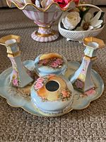 Four-piece antique porcelain vanity set including tray, two candlestick holders, and two covered dishes, each hand painted with pink roses and gold trim.