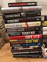Stack of Stephen White books with a few other authors, showing titles and spine details
