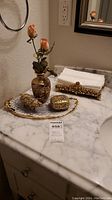 Complete vanity set on marble countertop showing cloisonne vase with flowers, two cloisonne boxes on a metal tray, and gold-tone tissue holder with floral motif.
