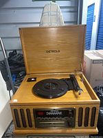 Full front view of the open Detrola wooden unit showing turntable, radio and control panel.