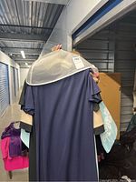 Dresses hanging on a rack viewed from the back, showing navy, black, beige and pastel colored dresses.