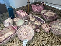 Overview of the various purple and cream Temptations ovenware set items including bowls, bakeware, and animal-shaped containers