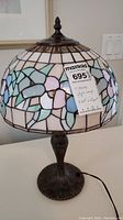 Tiffany style lamp with stained glass floral patterned shade and ornate metal base, including MaxSold tag