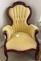 Front view of Victorian style upholstered accent chair showing mahogany frame and yellow upholstery