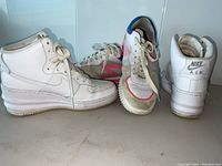 Photo showing two pairs of shoes side by side: white Nike Air Lunar Force platform shoes and Rag & Bone running shoes with pink and blue details.