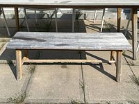 Front angled view showing weathered finish on bench top and legs.