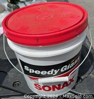 White SONAX bucket with red lid, labeled 'Speedy Glass SONAX'