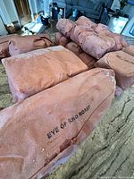 Vacuum-sealed frozen beef cuts wrapped in butcher paper labeled “Eye of Round Roast” and other cuts, arranged on kitchen counter.