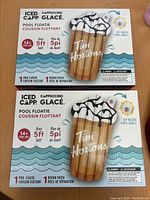 Box packaging of two Tim Hortons Iced Cappuccino pool floaties showing product information including size over 5 feet tall, cup holder, and repair patch included.