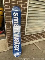 Blue top side of snowboard featuring white 'smartwater' branding.