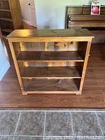 Front view of solid pine bookshelf showing three shelves and wood grain finish