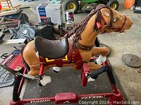 Side view of the Radio Flyer spring horse toy showing brown horse with saddle, springs, and red metal frame.