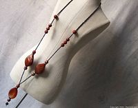 Full view of the artisan necklace displayed on a mannequin highlighting the full length, bead detailing, and arrangement of semi-precious stones.