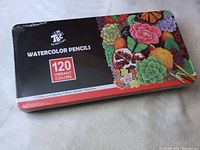 Sealed metal tin box with vibrant floral and fruit designs advertising 120 watercolor pencils by TBC.