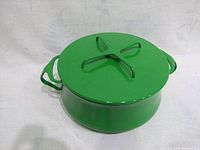 Green vintage Dansk Kobenstyle pot with lid on, showing side profile and lid handle.