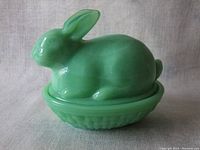 Front angle showing bunny lid resting on green basket base with subtle aged glaze.