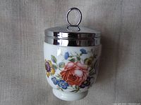 Front view of the large double egg coddler showing floral patterns and metal lid with loop handle.