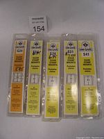 Front view of all five UNI-SAFE clear stamp mount packages showing sizes G24, S24, S26, S31, S41 with prices marked.