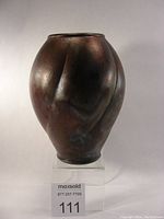 Front view of the raku vase, showing overall form and iridescent glaze finish with rich dark tones and metallic highlights.