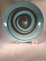 Front view of the large round bowl showing the blue base with a brown spiral swirl pattern.