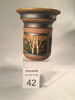 Front view of the Peter Price pottery vase showing its earthy tones with horizontal banding and textured bark finish on the body.