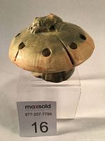 Side angle view of the mushroom figurine with frog on top, showing the shape and coloration.