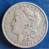 Obverse side of 1891 Morgan silver dollar showing Lady Liberty with date and motto.